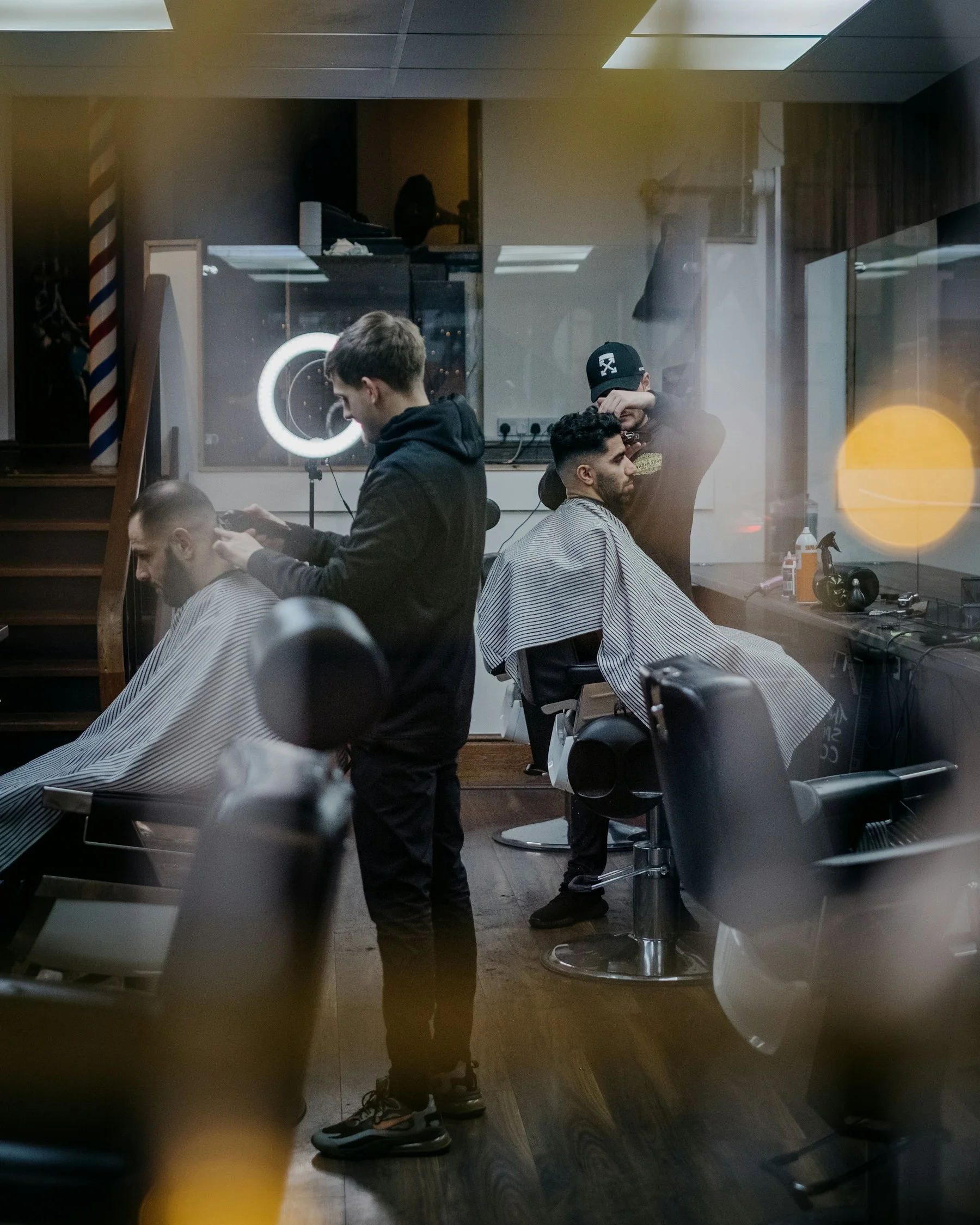 A barber working with a client in the chair