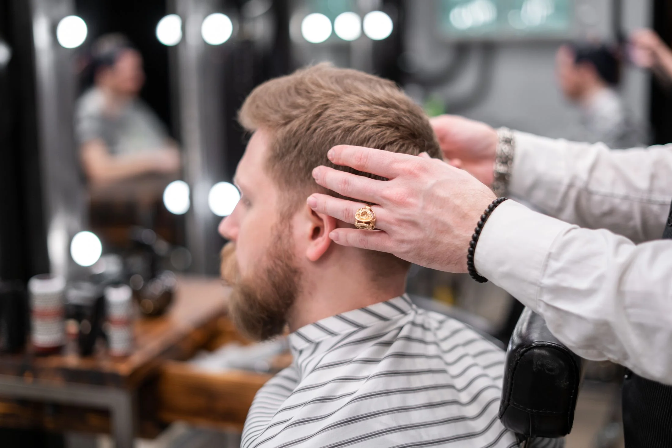 Barber checking a client's haircut in a working barbershop