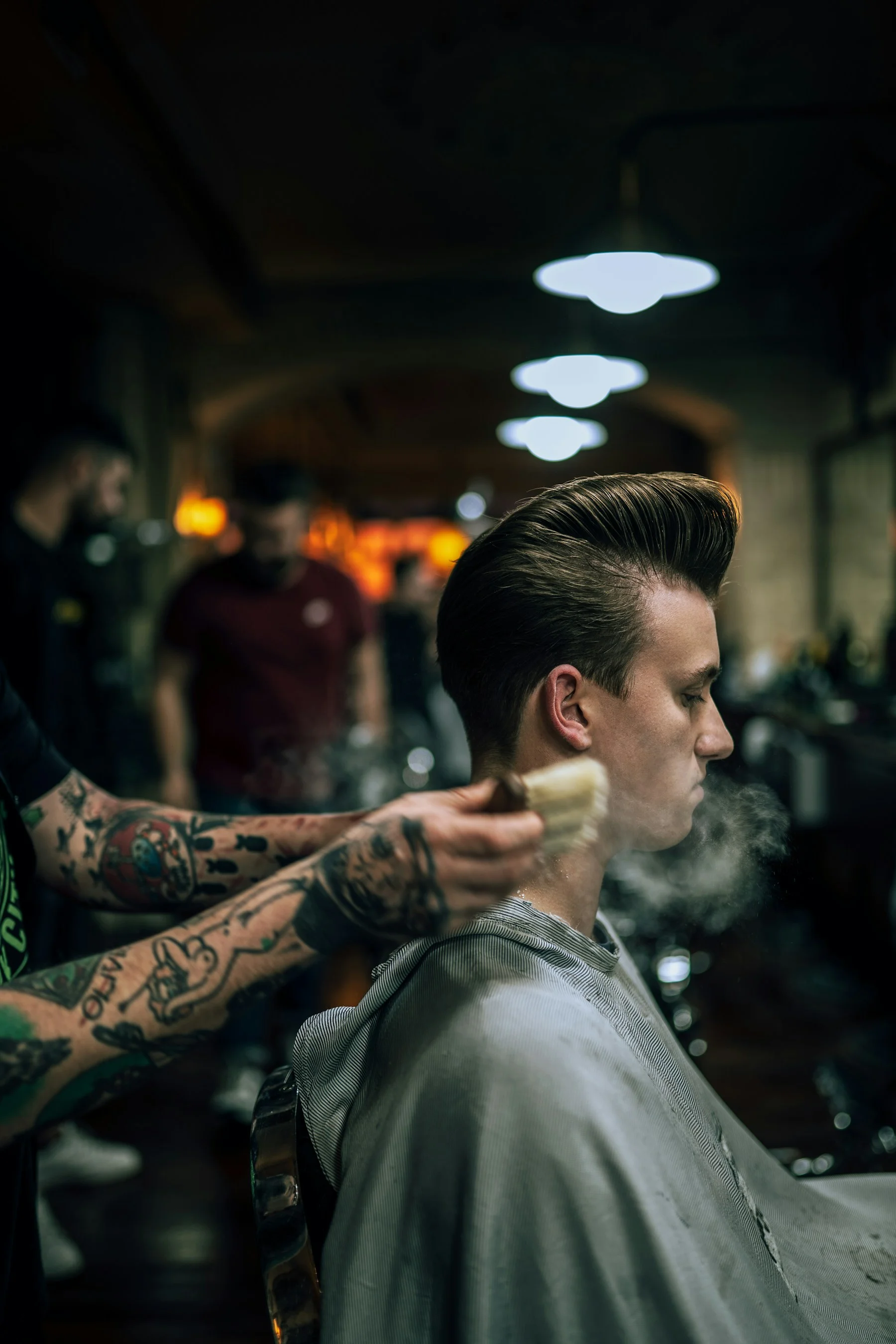 Barber finishing a client's haircut in a neighborhood shop