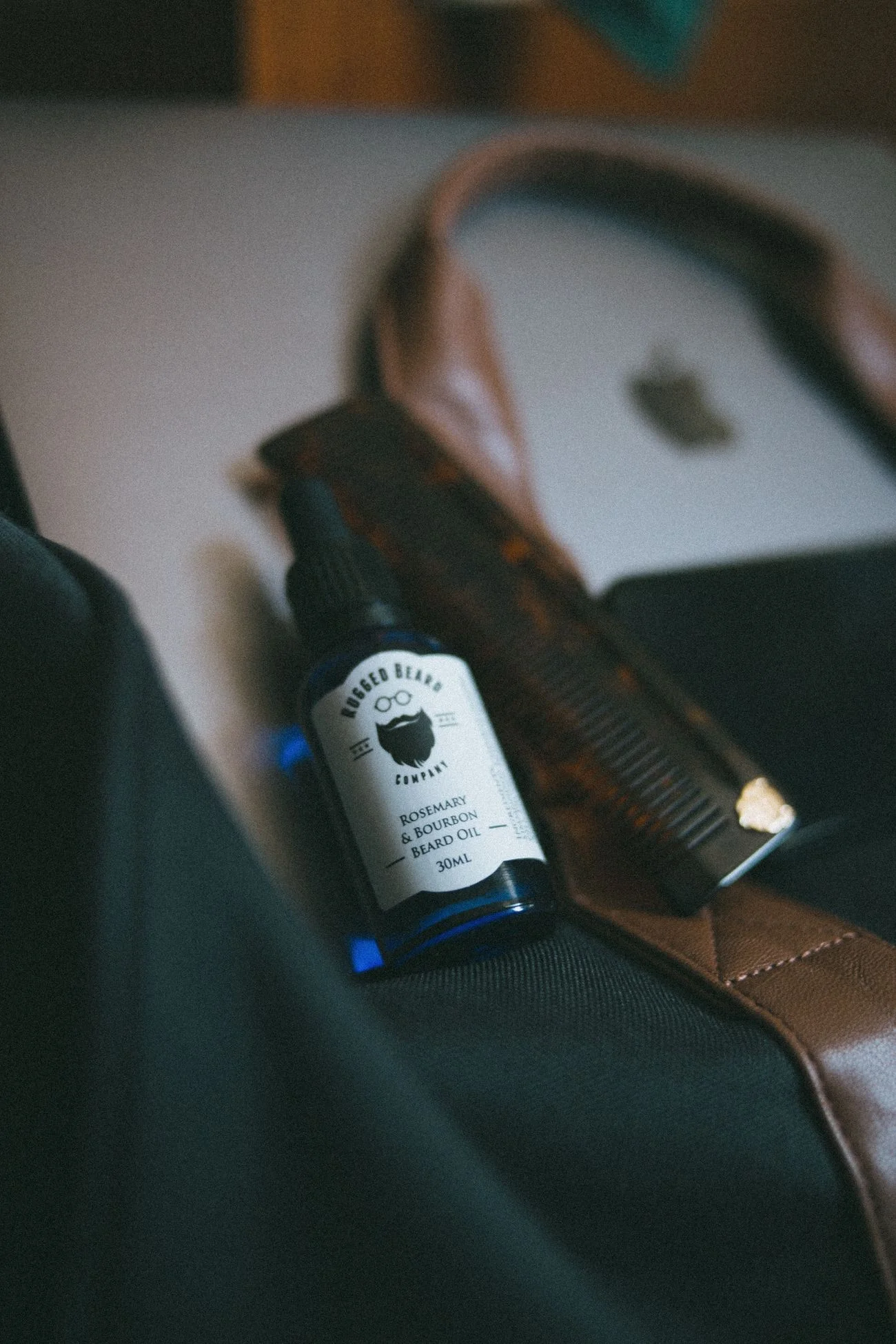 Stock photograph of a beard oil bottle with a comb